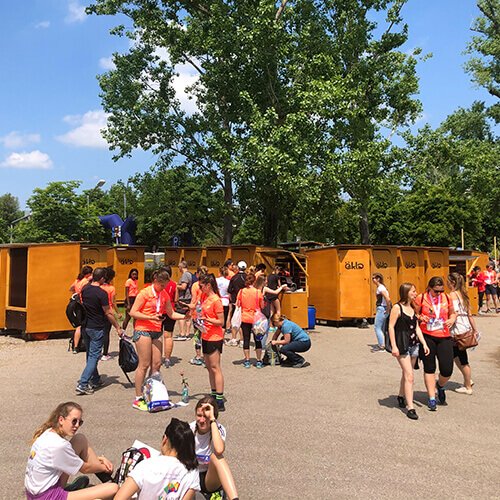 Toiletten von öKlo auf einer Sportveranstaltung mit vielen Menschen vor den WCs