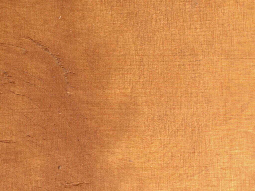 Ein Foto von Farbvariation in einer Holzplatte. Links ist die Maserung dunkler als auf der rechten Seite.